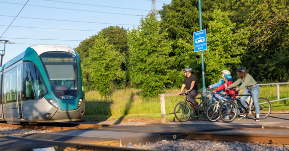 Image of tram and group cyclists at crossing