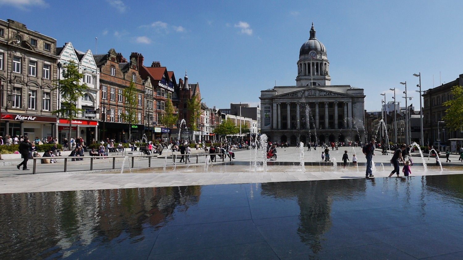 Building in square in Nottingham in the sun, fountains in front
